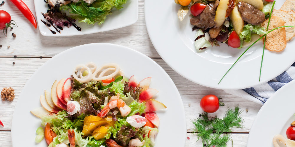 Warm salads assortment on restaurant table flat lay. Top view on buffet with variety of meat side dishes. Menu, banquet, food set, party concept